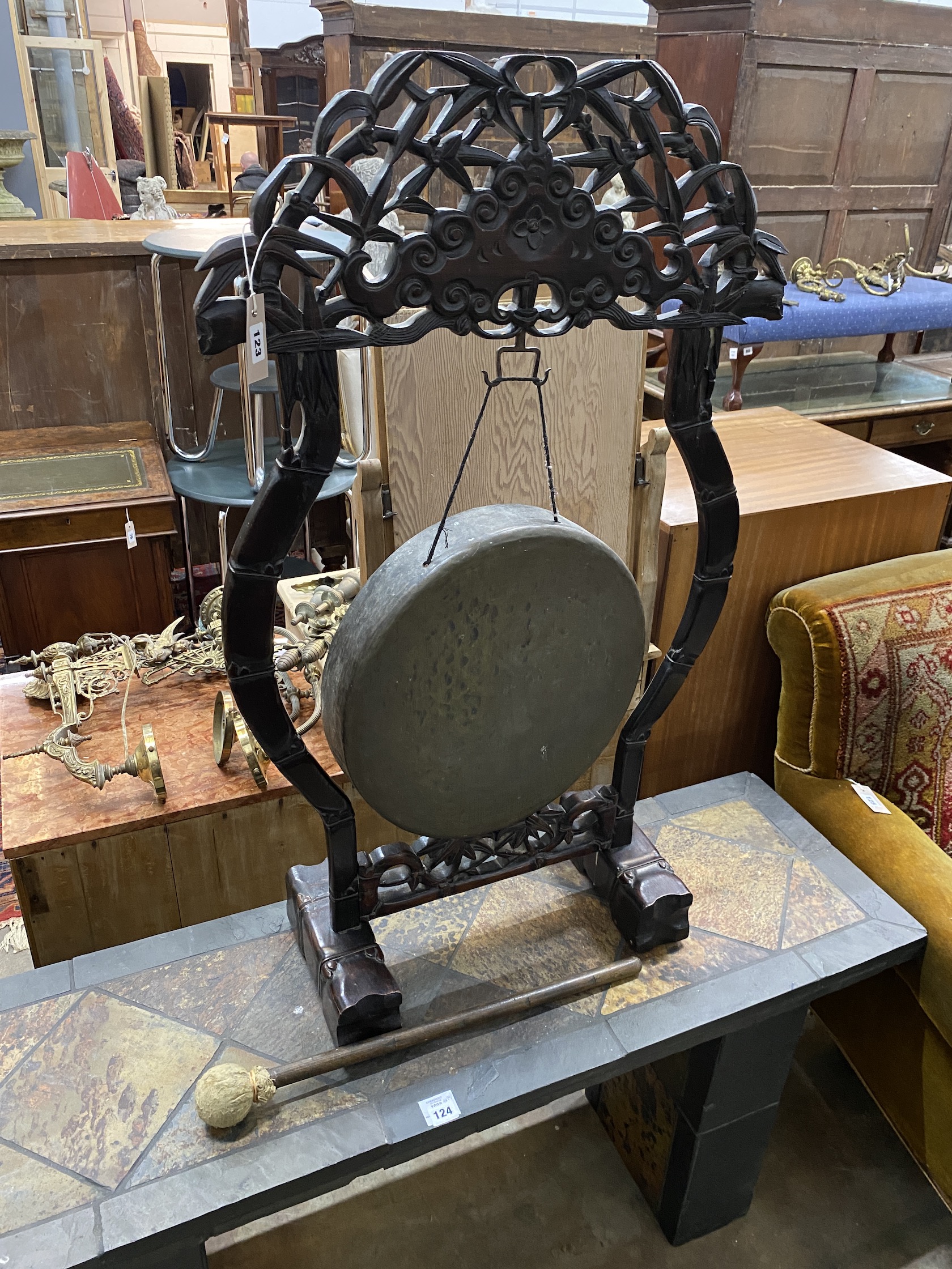 A Chinese carved hardwood gong with striker, width 64cm, height 106cm